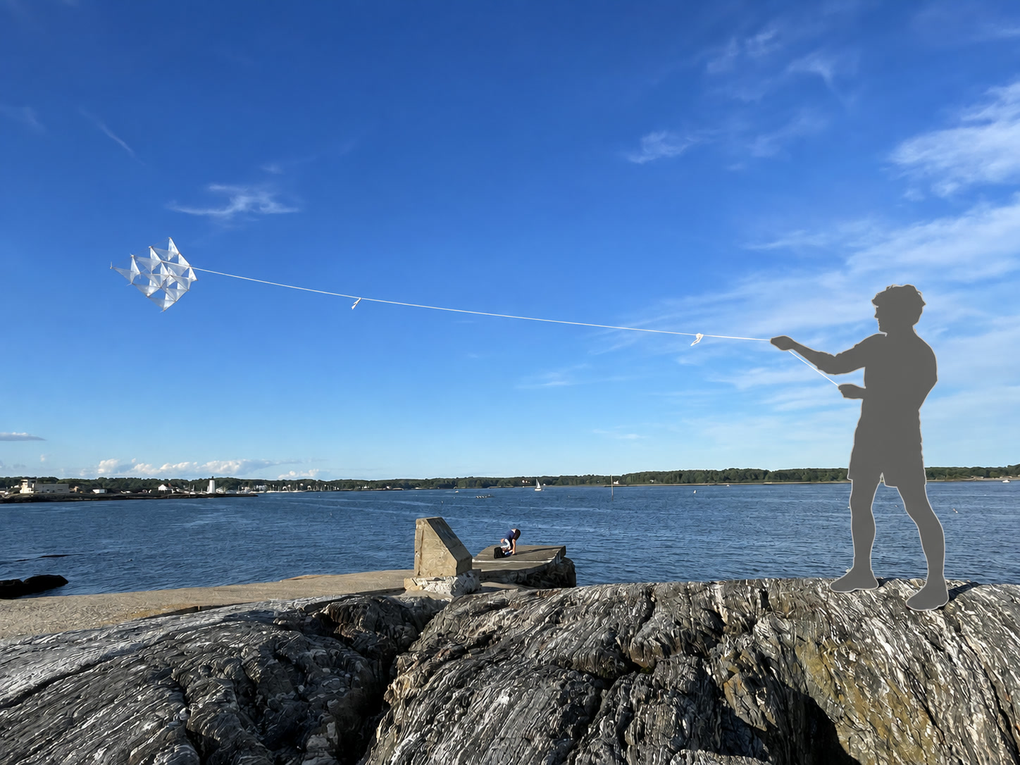A gray silhouette flies a translucent tetrahedral kite above blue water and a rocky shore